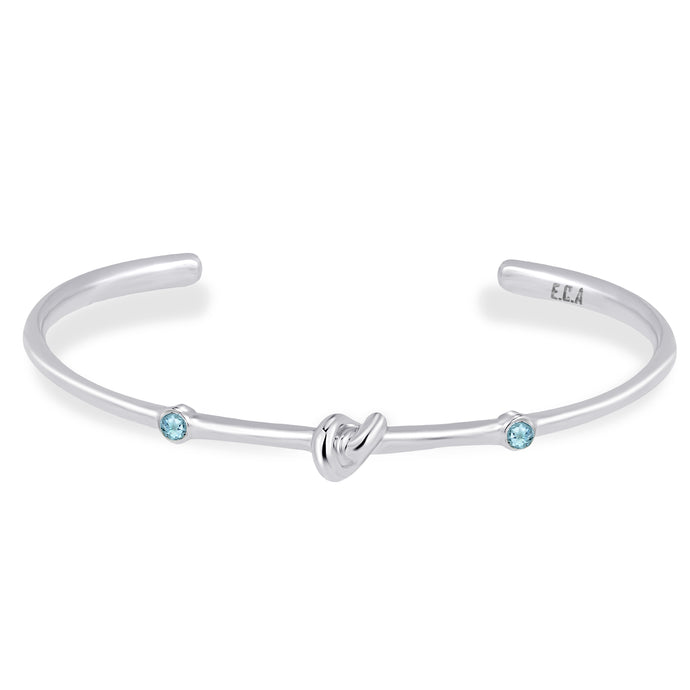 Love Knot Bracelet with White Topaz | Aquamarine  This simple design is handcrafted with Sterling Silver to convey the message of eternal love.  Sterling Silver   White Topaz: 2.5mm  Aquamarine: 2.5mm